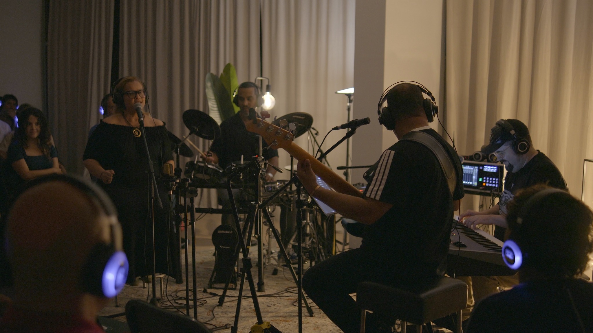 Artista convidada, baixista, baterista e pianista atuam diante do público